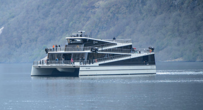 Sightseeingfartøy på cruise nær fjellsiden. Sightseeingfartøy på cruise nær fjellsiden.